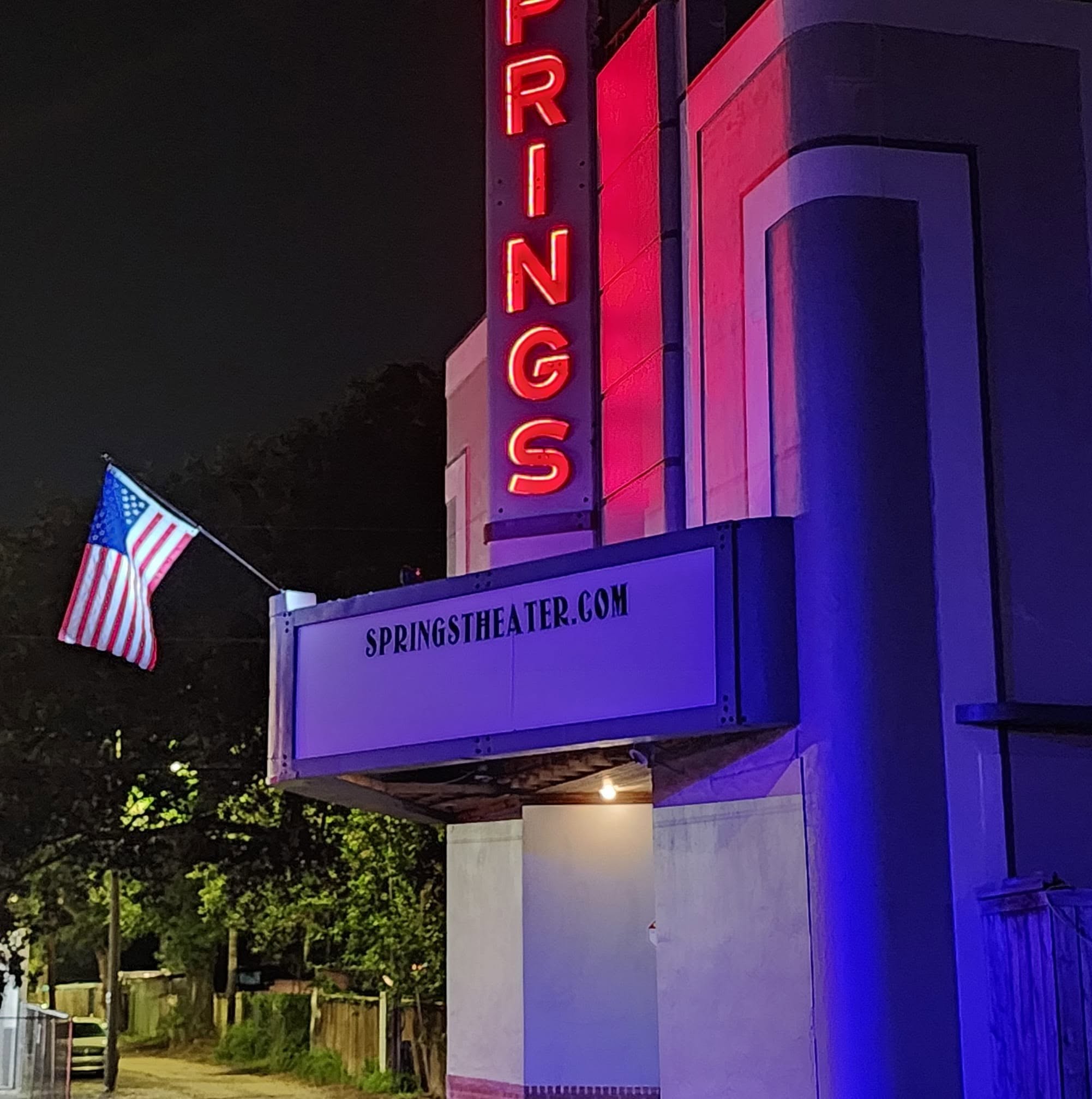 Springs Theater marquee glowing red, white and blue at night